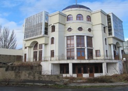 Адміністративна будівля, загальною площею 1 437,8 кв. м, за адресою: Херсонська обл., Генічеський р., м. Генічеськ, вулиця Центральна (Леніна), 1. Реєстраційний номер об’єкта нерухомого майна:  37841072.  Інвентарний № 88986. Земельна ділянка, площею 0,1404 га (кадастровий номер 6522110100:01:006:0002), за адресою: Херсонська обл., Генічеський р., м. Генічеськ, вулиця Центральна (Леніна), 1. Цільове призначення - для розміщення адміністративного відділення Промінвестбанку. Інвентарний номер 74315. Аванс м. Генiчеськ, Херсон.обл., м. Генiчеськ, вул.Ленiна,1 на виконання робіт з/рах. 101 від 29.12.2009. Інвентарний номер 443043000023.